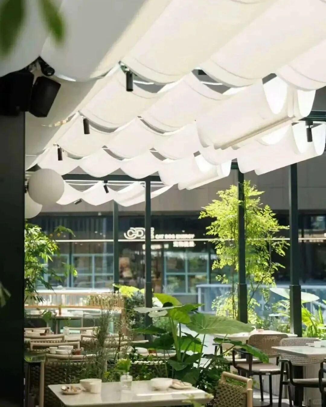 购物中心户外餐饮区座位与绿化实景，来自本期引用的原文配图