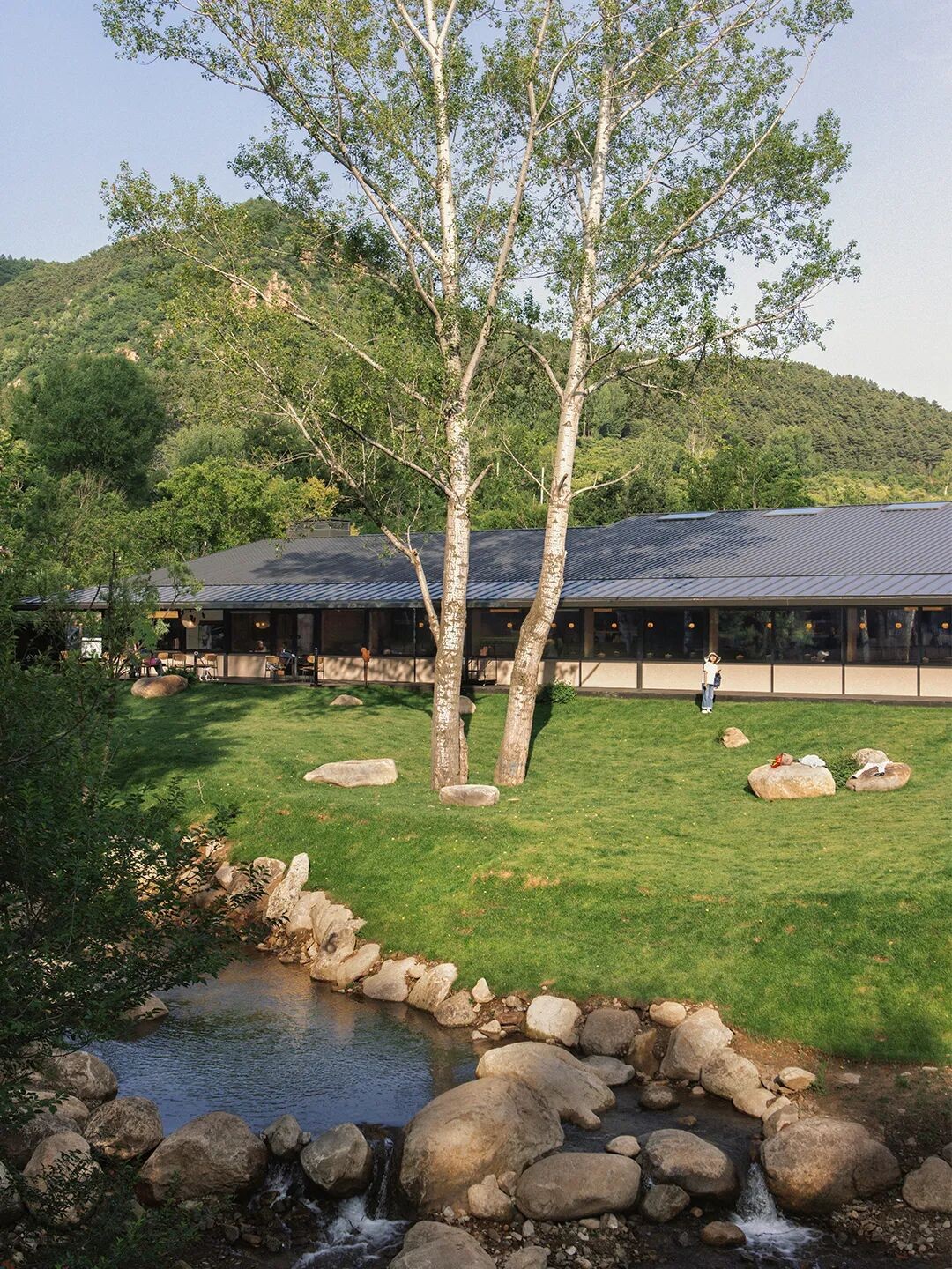 阿那亚雾灵山山食堂建筑外景（溪流与草坪前），青年建筑原文配图